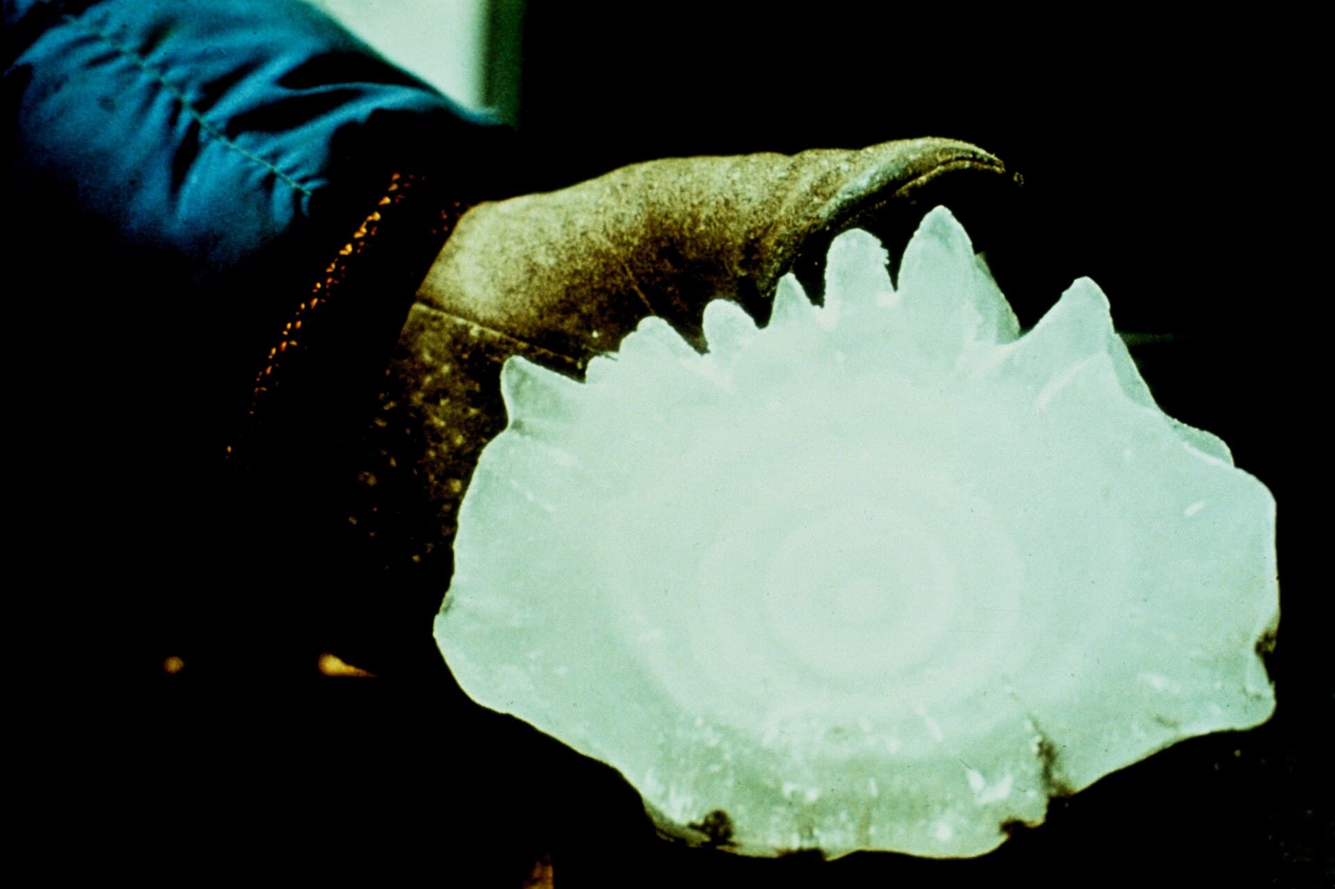 A giant hailstone held in a gloved hand